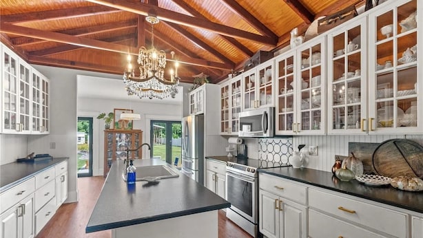 A kitchen with white cabinetry, a central island, stainless steel appliances, and a wooden ceiling. - Quiet Historic Family Retreat with Pool--Pet Friendly--No Events (Bushnell)