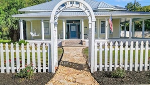 A house with a porch, a stone pathway, and a white picket fence. - Quiet Historic Family Retreat with Pool--Pet Friendly--No Events (Bushnell)