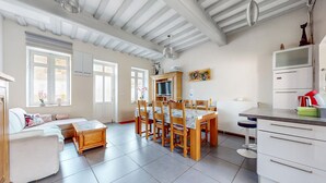 A spacious living area with a dining table and chairs, a sofa, a kitchen area with a refrigerator, and a TV. - Awesome home in Arques la Bataille (Arques la Bataille)