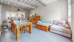 A spacious living area with a dining table, wooden chairs, a sofa, and a cabinet. - Awesome home in Arques la Bataille (Arques la Bataille)