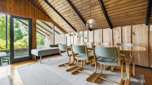 A cozy room with a wooden ceiling, large windows, a dining table with chairs, and a bench. - 2 bedroom lovely home in Melby (Melby)
