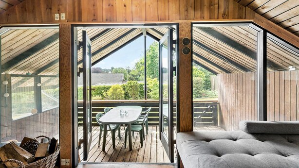 A wooden interior with a large sliding glass door leading to an outdoor deck. - 2 bedroom lovely home in Melby (Melby)