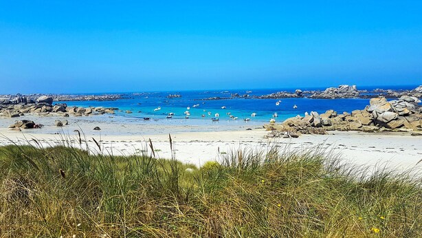 A beach with clear blue waters, rocky outcrops, and boats. - Beautiful apartment in Kerlouan with WiFi (Kerlouan)
