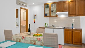 A compact kitchen with wooden cabinets, a built-in oven, and a sink. - Beautiful apartment in Lozovac with WiFi (Lozovac)