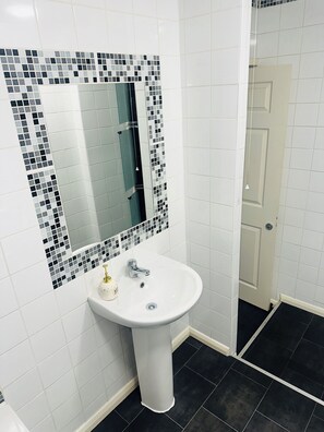 Regadera, secadora de cabello, toallas, papel de baño