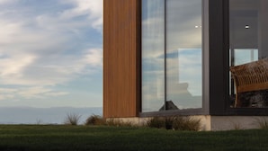 A modern building with large glass windows and a wooden facade.