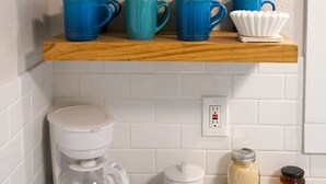 Una encimera de cocina con una cafetera, un tarro de miel y un cartel sobre café.