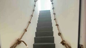 Un escalier avec des rampes faites de cordes.