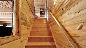 Un escalier en bois à l’intérieur d’une cabane en rondins.
