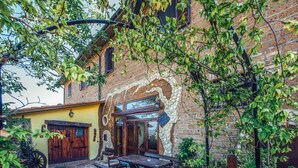 A rustic building with a stone facade, a wooden door, and a bench outside.