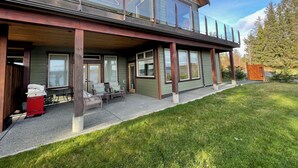 A modern two-story house with a covered patio, large windows, and a wooden deck. - Ridge View Suite Seascape Panorama with Covered Deck  (Campbell River)