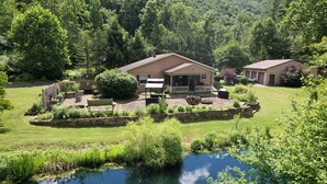 A house with a porch, a small pond, and a garden.