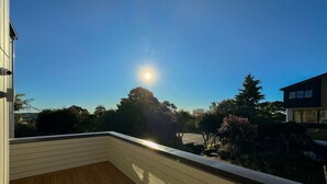 A wooden deck with a clear view of the sky and surrounding greenery.