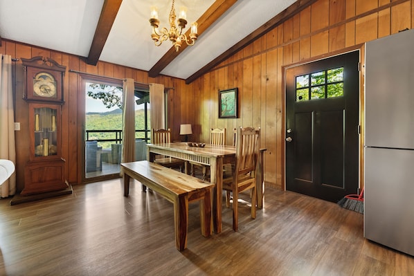 Enjoy meals at the dining table for four, with a view of the outdoors through the large window.