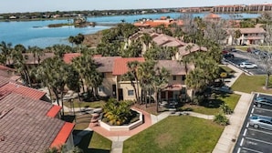 A hotel with a pool, surrounded by palm trees and a parking lot. - Home near Sea world/Universal/Convention center (Orlando)