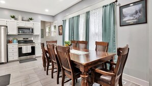 A modern kitchen with white cabinets, a built-in microwave, and a stainless steel refrigerator. - Wichita home, by the river, spacious 9 beds-game room with pool table, 1gb Wi-Fi (Wichita)