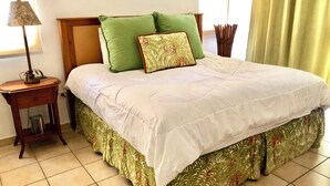 A neatly made bed with a green and white bedspread, a wooden headboard, and a green pillow. - Fairway Courts Studio in Palmas del Mar- Great Pool, Just Mins to Hotel/Beach (Humacao)