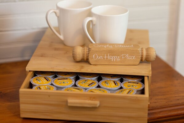 A wooden box with a label reading "Simply Blessed Our Happy Place" containing several yellow containers.