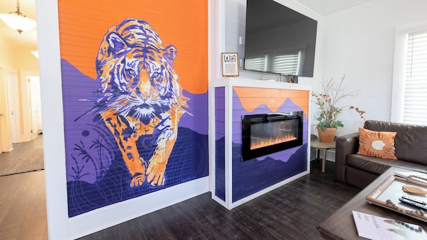 A living room with a large tiger mural, a fireplace, a sofa, and a coffee table.