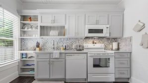 A kitchen with white cabinets, a microwave, a dishwasher, and an oven.