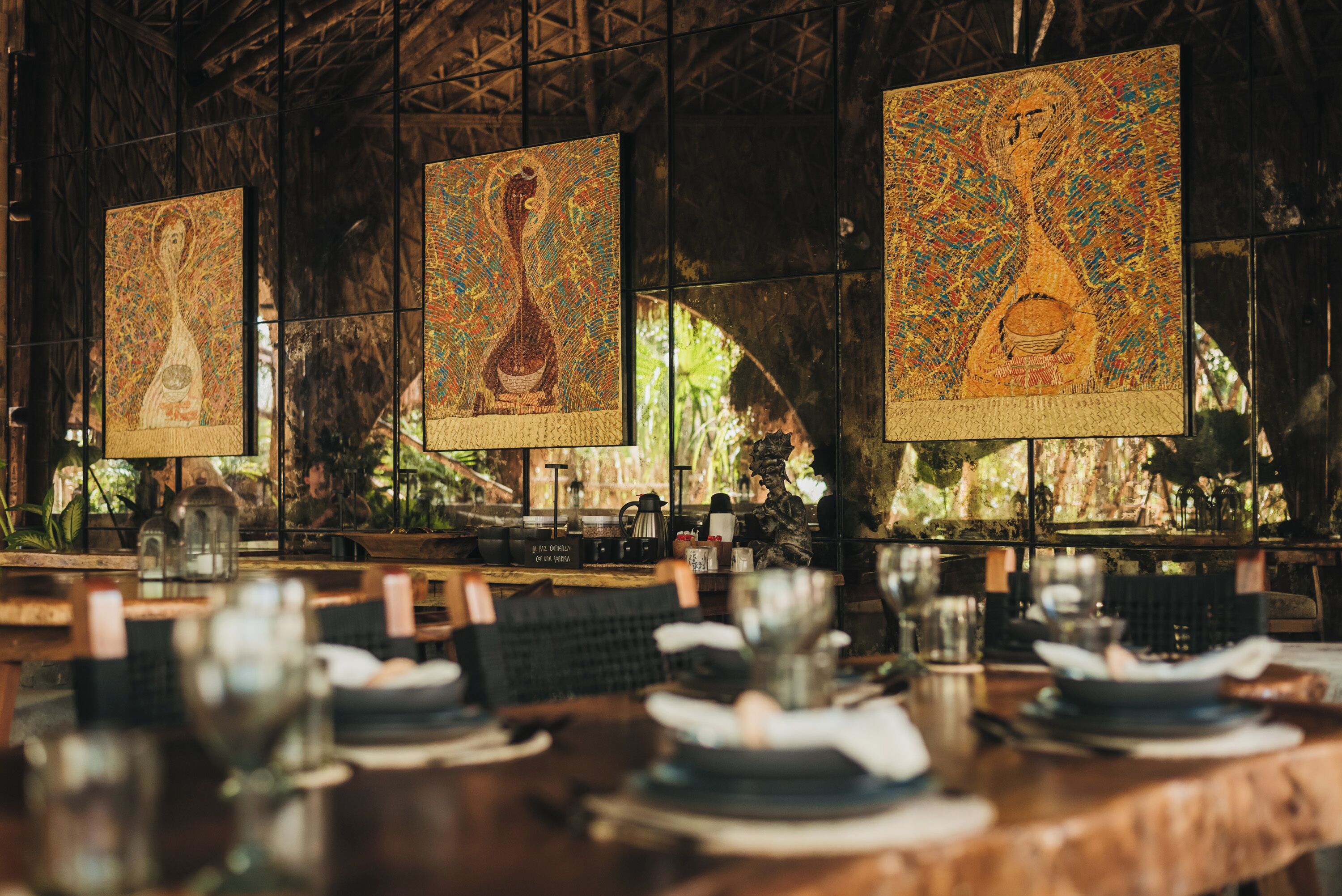 Un restaurante con detalles de mosaicos en las paredes, mesas y sillas de madera.