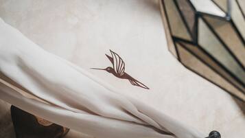 Tejido blanco con un diseño de pájaro, posiblemente un cojín o adorno decorativo.