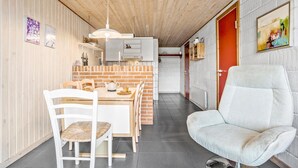 A compact kitchen with a brick backsplash, white cabinetry, and a hanging light fixture. - Beautiful home in Thisted (Thisted)
