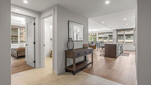 A spacious open-plan living area with a kitchen, dining area, and a bedroom with a large window. - Spacious Premier Mountain Retreat conveniently located in Spring Creek! (Canmore)