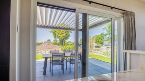 A modern kitchen with a sliding glass door leading to an outdoor patio area. - 2 bedroom amazing home in Voorthuizen (Voorthuizen)