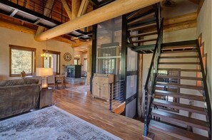 Cozy seating area with a sofa and table, featuring a lamp and staircase leading to an upper level.
