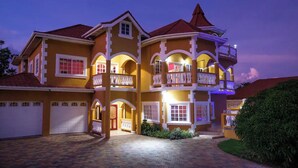 A multi-story house with a central courtyard, multiple balconies, and a garage.