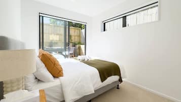 Une chambre à coucher avec un lit, une fenêtre et une table de chevet.