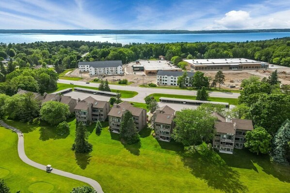 Un quartier résidentiel comprenant plusieurs immeubles d’appartements, un terrain de golf et, au loin, un plan d’eau.