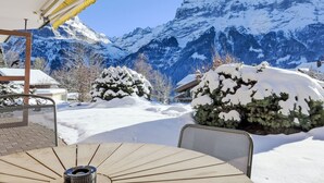 Ein mit Schnee bedeckter Außenbereich mit Blick auf schneebedeckte Berge.