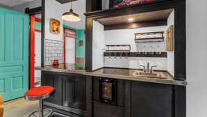 Una cocina con horno empotrado, un lavabo y una estantería para vinos.