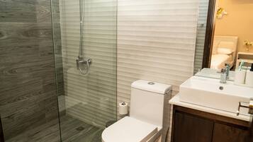 Een douche, handdoeken, zeep, toiletpapier