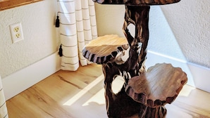 A round wooden table with a unique design, featuring a small potted plant on top. - Cedar-sided cabin, RV parking, Kids & Pet friendly (Ashford)
