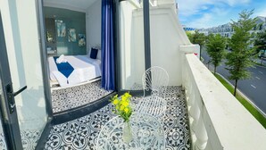 A hotel room with a bed, a bathroom, and a balcony with a view of the street. - Lala Boutique Phu Quoc (Phu Quoc)