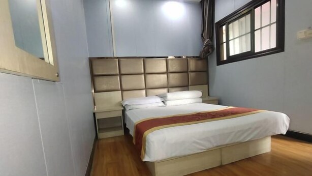 A bedroom with a bed, a headboard, a window, and a mirror. - Xi'an Lianhu District Hospitality Hotel (Xi'an)