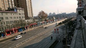 A city street with buildings, a road, and a few vehicles. - Xi'an Lianhu District Hospitality Hotel (Xi'an)