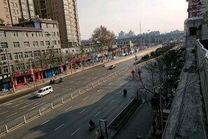A city street with buildings, a road, and a few vehicles.