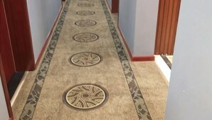 A carpeted hallway with a patterned border and circular designs. - Xi'an Lianhu District Hospitality Hotel (Xi'an)