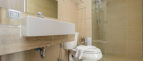 A bathroom with a sink, toilet, and shower.