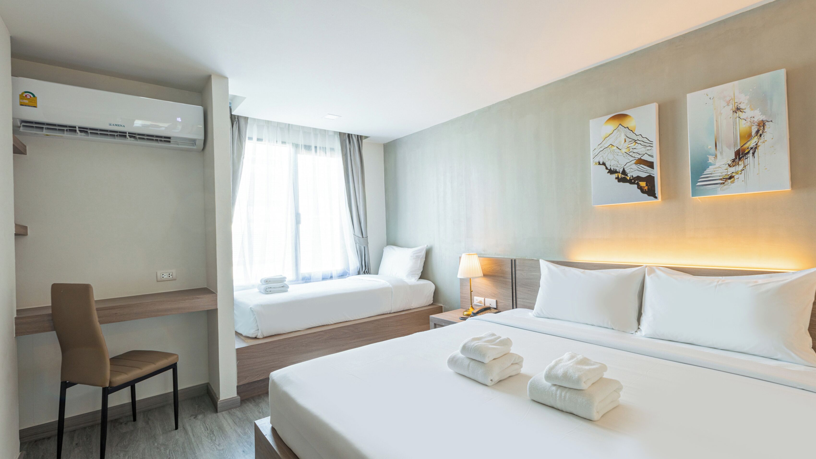 Une chambre d’hôtel avec un lit, un bureau, une chaise et une fenêtre avec des rideaux.