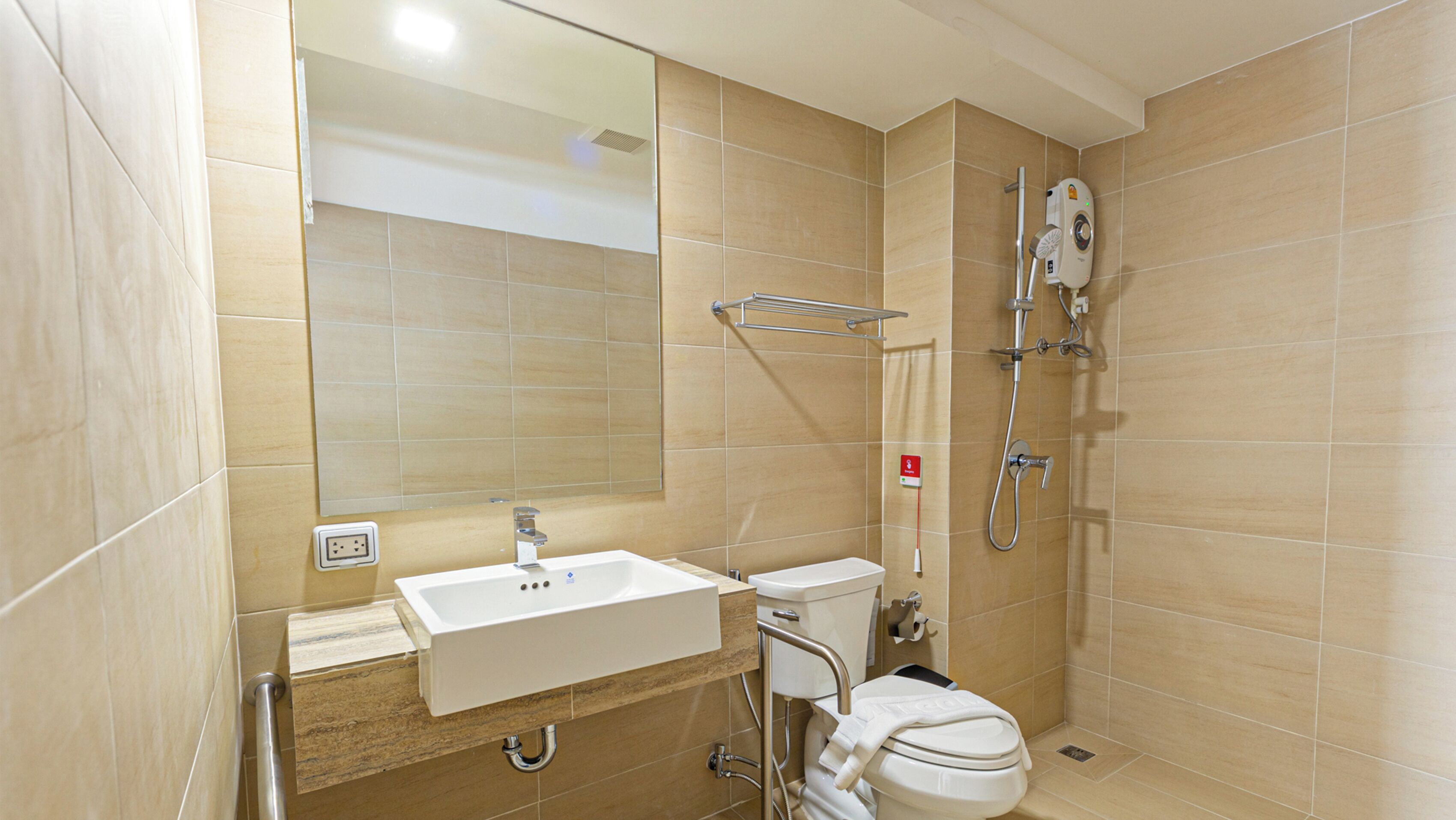 Un baño moderno con lavamanos, inodoro y ducha.