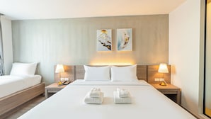 A hotel room with a large bed, two bedside tables with lamps, a nightstand, and two wall-mounted artworks. - B2 Khon Kaen Wufoo Market Premier Hotel (Khon Kaen)