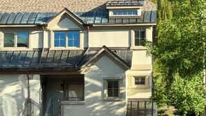 A two-story house with a garage, a covered porch, and a staircase leading to the entrance. - Large Cozy Townhouse Ski-in / Ski-out to Super Bee, Private Washer /Dry & Garage (Frisco)