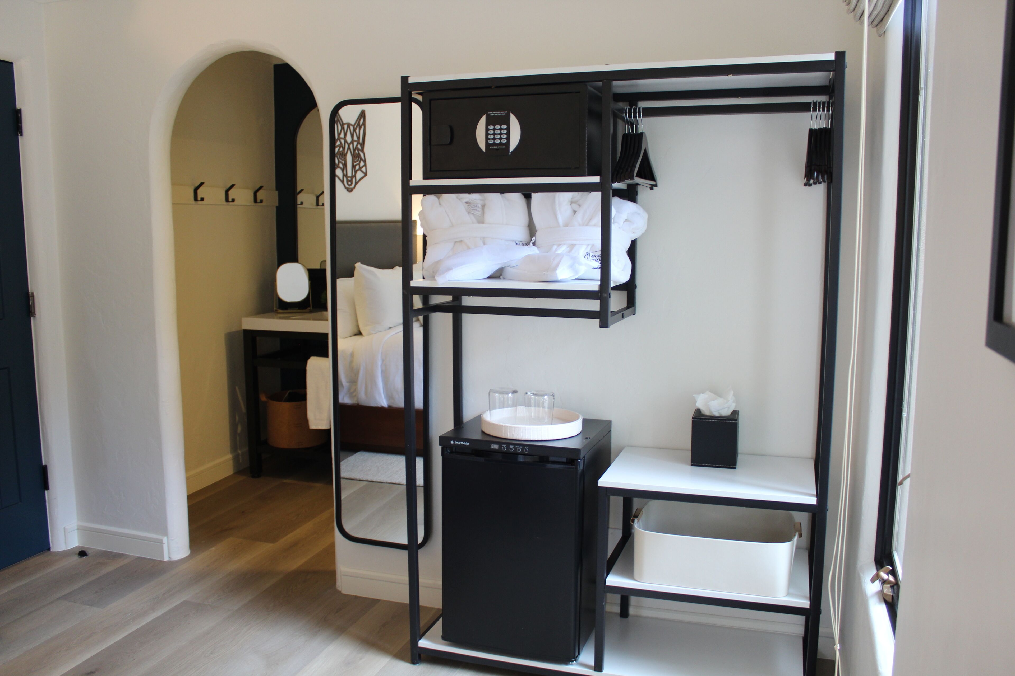 Une chambre d’hôtel compacte avec un lit superposé, une petite kitchenette et une table de chevet.