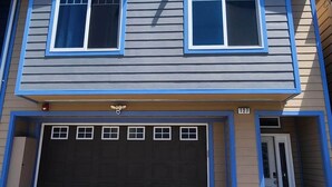 A two-story house with a garage, a number 127, and a paved driveway.