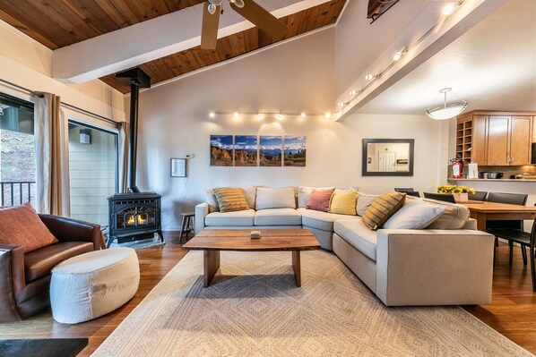 Una sala de estar acogedora con un sofá modular, una mesita de centro y una chimenea.